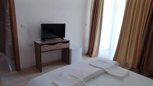 ein Schlafzimmer mit einem Bett und einem TV auf dem Tisch in der Unterkunft ARIA in Primorsko
