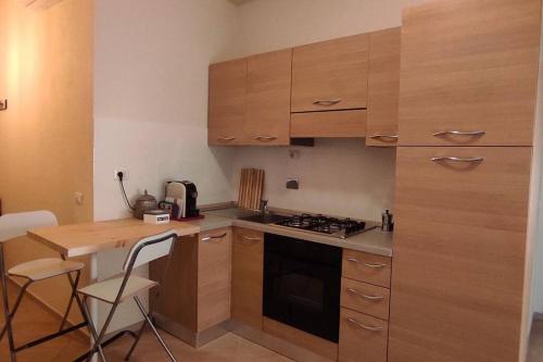 斯坎迪奇的住宿－La Casetta tra Chianti e Firenze，厨房配有木制橱柜和炉灶烤箱。