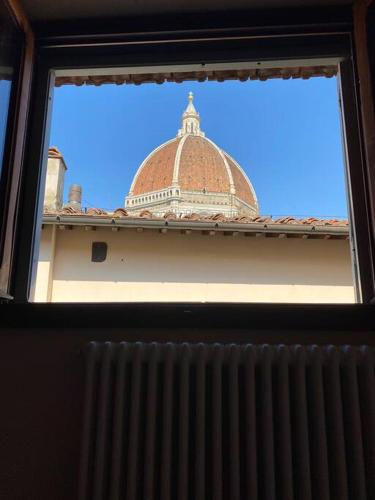 une fenêtre donnant sur un bâtiment avec un dôme dans l'établissement Appartamento al Duomo, à Florence