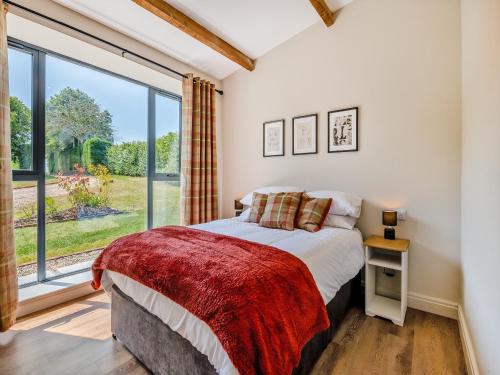 a bedroom with a bed and a large window at The Warren - Uk42858 in Rise