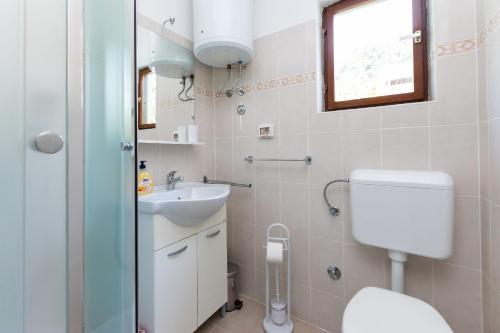 a bathroom with a toilet and a sink at Apartment Miljenko in Lopar
