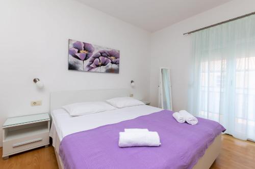 a bedroom with a bed with two towels on it at Apartment Miljenko in Lopar