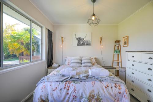 a bedroom with a bed with pillows and a window at Sunny Inn Tawavale in Rotorua