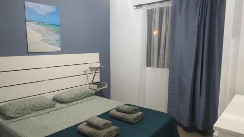 una camera da letto con un letto e asciugamani di Endless Summer apartment (San valentin) a Corralejo