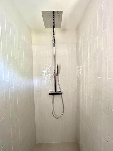 La salle de bains carrelée de blanc est pourvue d'une douche avec un pommeau de douche. dans l'établissement Studio Love Les Orangers - Piscine - 15mn plage - 5 kms, à Six-Fours-les-Plages