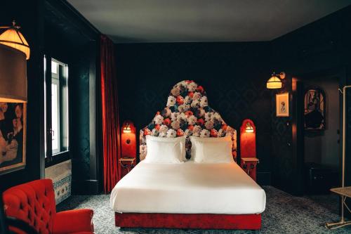 Pensão Amor Madam's Lodge في لشبونة: غرفة نوم بسرير ابيض عليها شجرة عيد الميلاد