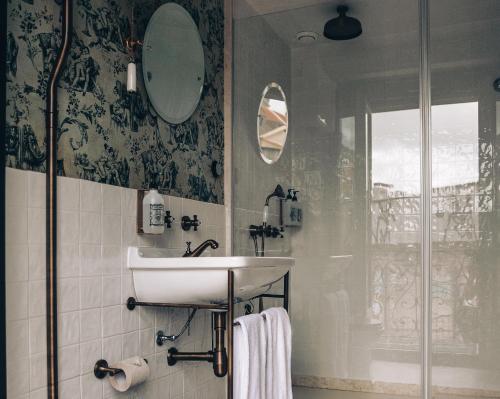 a bathroom with a sink and a shower at Pensão Amor Madam's Lodge in Lisbon