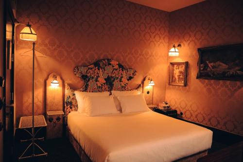 a bedroom with a large white bed with two lights at Pensão Amor Madam's Lodge in Lisbon