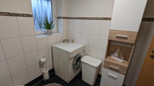 a small bathroom with a washing machine and a window at Familien Apartments in bester Lage in Butjadingen