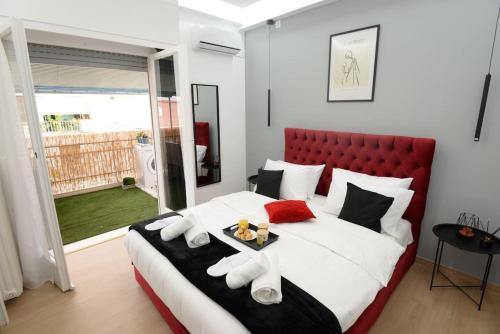 a bedroom with a large bed with a red headboard at Penthouse in the Heart of Athens in Athens