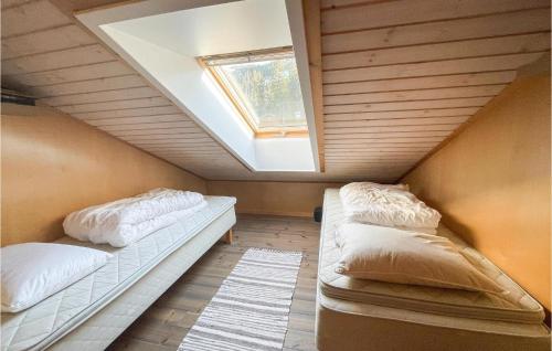 2 camas en una habitación pequeña con tragaluz en Lovely Apartment In Fvang With Wifi, en Favang