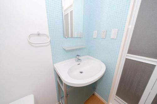 La salle de bains est pourvue d'un lavabo et d'un miroir. dans l'établissement Granduo 松濤, à Tokyo