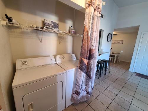 2bed 1 bath condo near Nellis afb & the strip في لاس فيغاس: مطبخ مع غسالة ومجفف في الغرفة