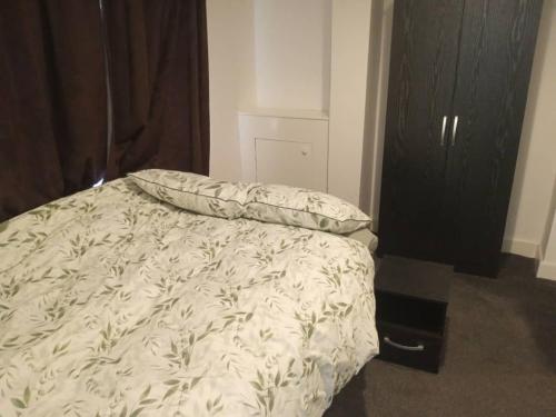 a bed with a white comforter and a pillow at Ensuite double-bed (G1) close to Burnley city centre in Burnley