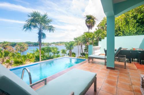 a swimming pool on a patio with a view of the water at Coral Vista #5 Home in Roatan