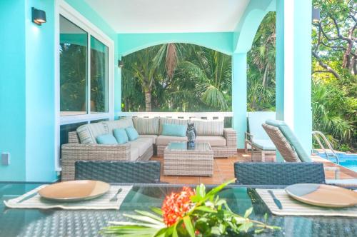 a patio with a couch and chairs and a table at Coral Vista #5 Home in Roatan