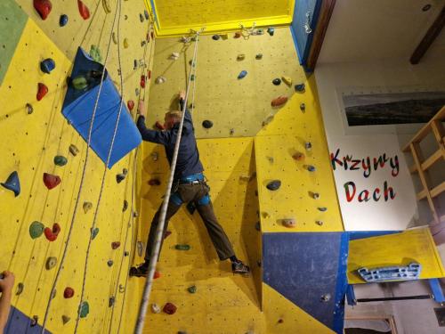 a man on a climbing wall in a gym at Pokoje pod Krzywym Dachem in Karpniki