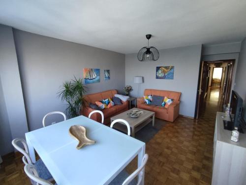- un salon avec une table et un canapé dans l'établissement Acogedor piso en primera línea de mar- 8 huéspedes, à A Guarda