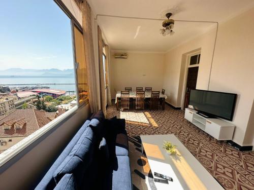 a living room with a couch and a large window at Résidence Bejaia Legacy in Bejaïa