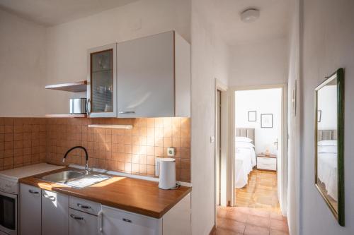 una cocina con fregadero y una cama en una habitación en Apartment Mango, en Vinišće