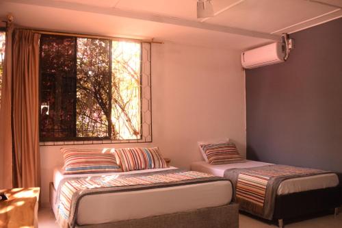 Cette chambre comprend 2 lits et une fenêtre. dans l'établissement Yosu Hostal, à Ríohacha