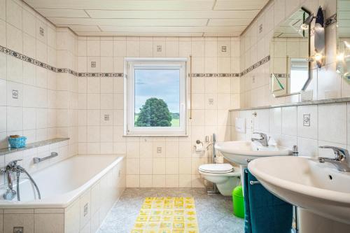 a bathroom with a tub and a sink and a toilet at Urlaub auf dem Hirschhof Stehle in Waldburg