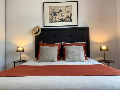 a bedroom with a large bed with red and white pillows at Élégance et Confort entre Disney et Val d'Europe 6 Personnes+Parking in Serris