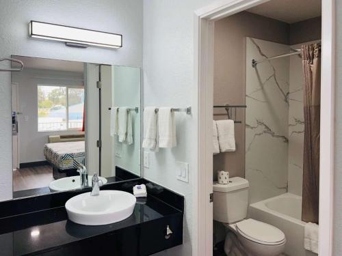 a bathroom with a sink and a toilet and a mirror at Motel 6-La Mesa, CA - San Diego in La Mesa