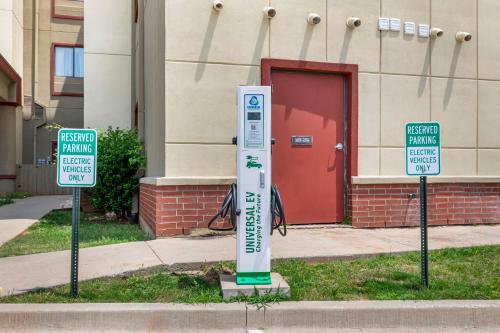 a parking meter in front of a building with two signs at Best Western Plus Texoma Hotel & Suites in Denison