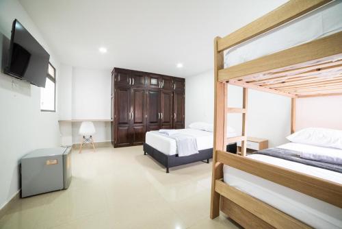 1 dormitorio con 2 literas y TV de pantalla plana en Tu Refugio Acogedor en el corazón de Medellín Hab Privada A, en Medellín