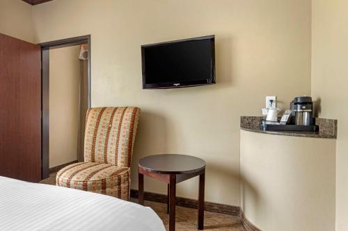 a hotel room with a bed and a chair and a television at Best Western Plus Texoma Hotel & Suites in Denison