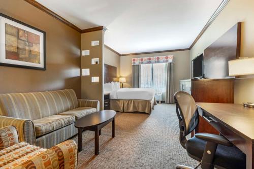 une chambre d'hôtel avec un canapé et un lit dans l'établissement Best Western Plus Texoma Hotel & Suites, à Denison