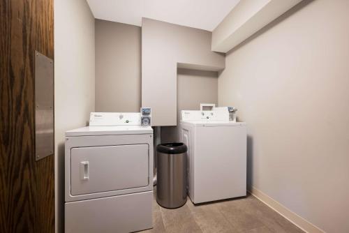 a small room with a refrigerator and a trash can at Best Western Executive Inn in Battle Creek