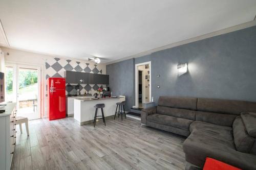 Montecolo Bay 1 في Pilzone: غرفة معيشة مع أريكة وثلاجة حمراء