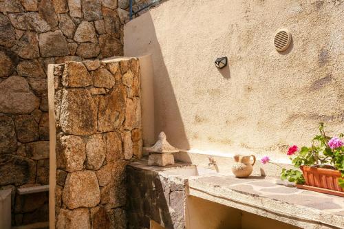 bagno con lavandino e parete in pietra di Villetta Fabi a San Teodoro