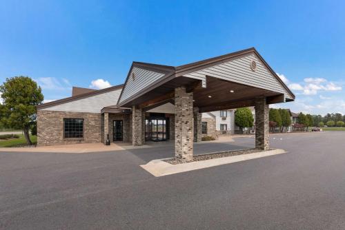 a building with a roof on a parking lot at Best Western Derby Inn in Eagle River