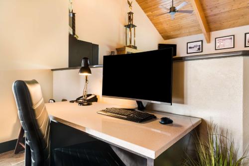 a desk with a computer monitor and a keyboard and mouse at Best Western Derby Inn in Eagle River