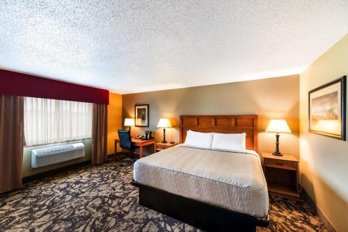 a hotel room with a bed and a desk and a window at Best Western Derby Inn in Eagle River