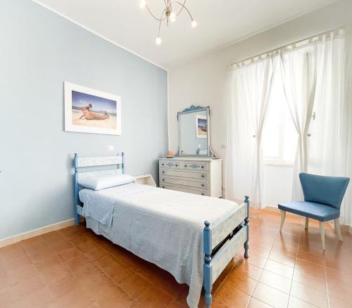 - une chambre avec un lit, une chaise et un miroir dans l'établissement BLUE HOUSE - incantevole casa a due passi dal mare, à Grottammare