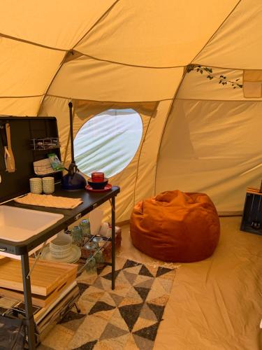 Una habitación con una tienda con una mesa. en Tal-y-fan farm (5m luna tent), en Bridgend