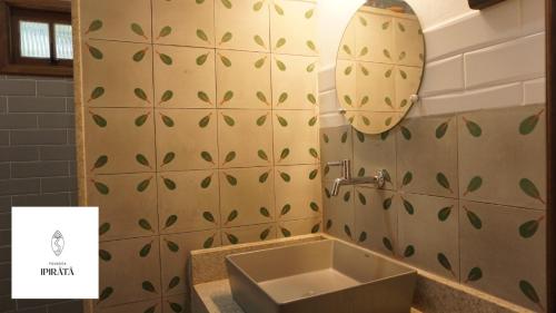 a bathroom with a sink and a light on the wall at POUSADA IPIRÃTÃ - Turismo de Vivência Cultural in Soure