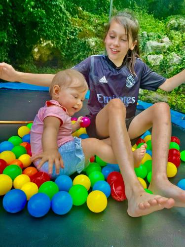 a young girl and a baby sitting in a pool of balls at Auto camp Radoman in Virpazar