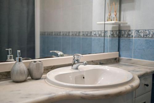 W łazience znajduje się umywalka i lustro. w obiekcie Central Apartment in Belas, Lisbon w mieście Belas