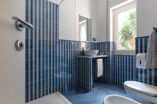 bagno piastrellato blu con lavandino e servizi igienici di B&B Sapore di Mare nel Blu a Gaeta