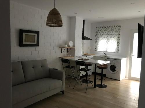 Trasariz Suites 1 في Vimianzo: مطبخ وغرفة معيشة مع أريكة وطاولة