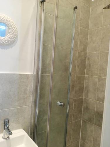 a shower with a glass door next to a sink at Ensuite Double-bed (G3) close to Burnley city centre in Burnley