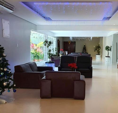 Flat próximo das praias e do shopping في ساو فيسينتي: غرفة معيشة مع كنب و شجرة عيد الميلاد