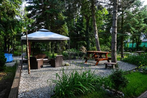 a garden with a gazebo and a picnic table at Pokoje gościnne „SEN” in Iława