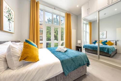 a bedroom with two beds and a large window at Modern 3 and 2 bedroom flat in central london with full AC in London