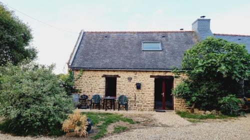 a brick house with a table and chairs in front of it at Gite cosycool in Languidic